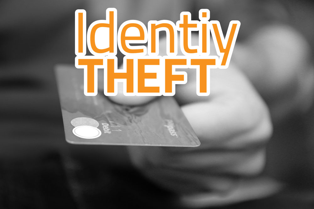 Image of a hand holding a credit card with the words "identity theft" written across the front